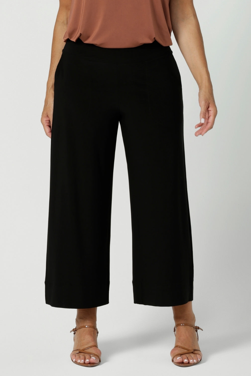 Close up image of wide leg black culottes worn by size 12 woman. Black workwear pants are crafted with dry touch jersey fabric. Shop online at Australian women's fashion brand Leina & Fleur in a variety of sizes from 8-24. Bradley Pants now available in 2 heights.