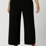 Close up image of wide leg black culottes worn by size 12 woman. Black workwear pants are crafted with dry touch jersey fabric. Shop online at Australian women's fashion brand Leina & Fleur in a variety of sizes from 8-24. Bradley Pants now available in 2 heights.