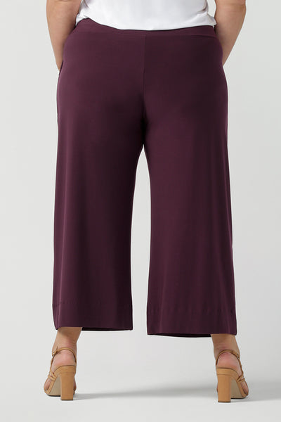 Close up back view of womens stretch work pants. Plus size womens fashion on size 18 in stretch jersey. Size inclusive fashion. Wide leg pant in Mulberry. 