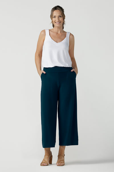 a plus size 18, fuller figure woman wears a bamboo cami. In white bamboo jersey, this top is a good addition to your capsule wardrobe for weekend wear, work and travel. Shop Australian-made dresses online is sizes 8 to 24. Pictured with Petrol jersey culotte pants.