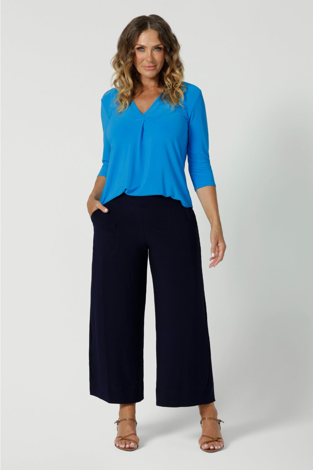 Wide leg black culotte pants worn with a 3/4 sleeve, v neck top in opal blue made from dry touch jersey. Worn by size 12 woman - shop online at Australian women's clothing brand Leina & Fleur in sizes 8-24, with regular & short lengths available.