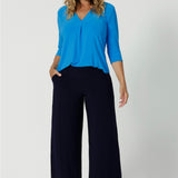 Wide leg black culotte pants worn with a 3/4 sleeve, v neck top in opal blue made from dry touch jersey. Worn by size 12 woman - shop online at Australian women's clothing brand Leina & Fleur in sizes 8-24, with regular & short lengths available.