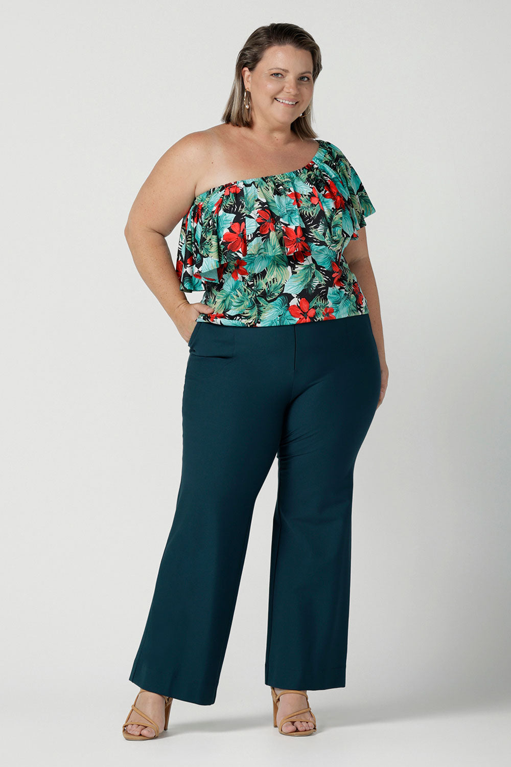 One shoulder Briar Top in Havana on a size 18 model. Tropical print design with red flowers and green palm leaf. Soft slinky jersey. Wear this top multiple ways one shoulder, off shoulder and on shoulder. Styled back with Brett pants in Petrol. Made in Australia for women size 8 - 24.