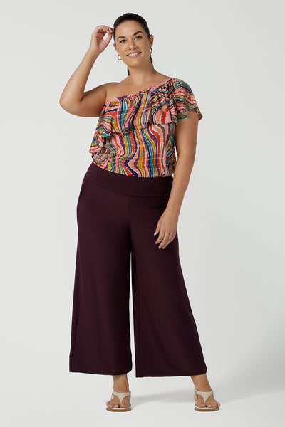 A size 12 one shoulder top woman wears an off shoulder top in vibrant rainbow swirl Briar top in soft slinky jersey. Made in Australia for women size 8 - 24.
