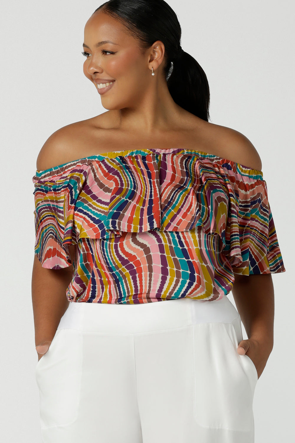 Curvy size 16 woman wears an off shoulder top in vibrant rainbow swirl Briar top in soft slinky jersey. Made in Australia for women size 8 - 24.