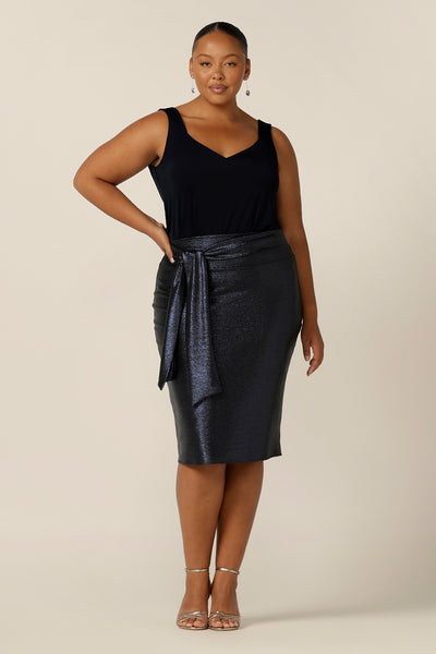 A great skirt for plus size and fuller figure evening and event wear, the Brooke Tube Skirt is made in shimmering stretch jersey and available in an inclusive size range of 8 to 24. A midnight blue, below-the-knee-skirt, this comfortable occasionwear skirt is worn with a navy camisole top in slinky jersey and belted with the Cyrus Neck Tie in midnight blue Xanadu glimmer fabric. 
