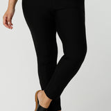 Close up of a size 12 woman wearing a slim leg, cropped length black pants for work wear and weekend wear are worn with a V-neck white bamboo jersey top with flutter sleeves. These stretchy women's trousers make great pants for your capsule wardrobe. Made in Australia by Australian and New Zealand women's clothing label, L&F.