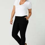 Slim leg, cropped length black pants for work wear and weekend wear are worn with a V-neck white bamboo jersey top with flutter sleeves. These stretchy women's trousers make great pants for your capsule wardrobe. Made in Australia by Australian and New Zealand women's clothing label, L&F.