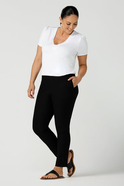 Slim leg, cropped length black pants for work wear and weekend wear are worn with a V-neck white bamboo jersey top with flutter sleeves. These stretchy women's trousers make great pants for your capsule wardrobe. Made in Australia by Australian and New Zealand women's clothing label, L&F.