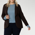Featuring a classic round neckline and long sleeves, it’s designed with comfort in mind — offering generous stretch and a smooth, breathable feel, without the itch of traditional merino. Size 18 model wears cocoa Merit Blazer over wool top, paired with womens navy work pants.