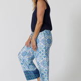 Side view of a pretty pyjama set that's great for over 40s women. A size 12 woman wears straight leg pyjama pants with blue and white print and a navy blue bamboo jersey cami top with wide shoulder straps. Thermo-regulating and breathable, these pajamas pants with drawstring ties and good pyjamas for night sweats and hot flushes. Shop loungewear sets online at L&F Australia in sizes 8 to 24.