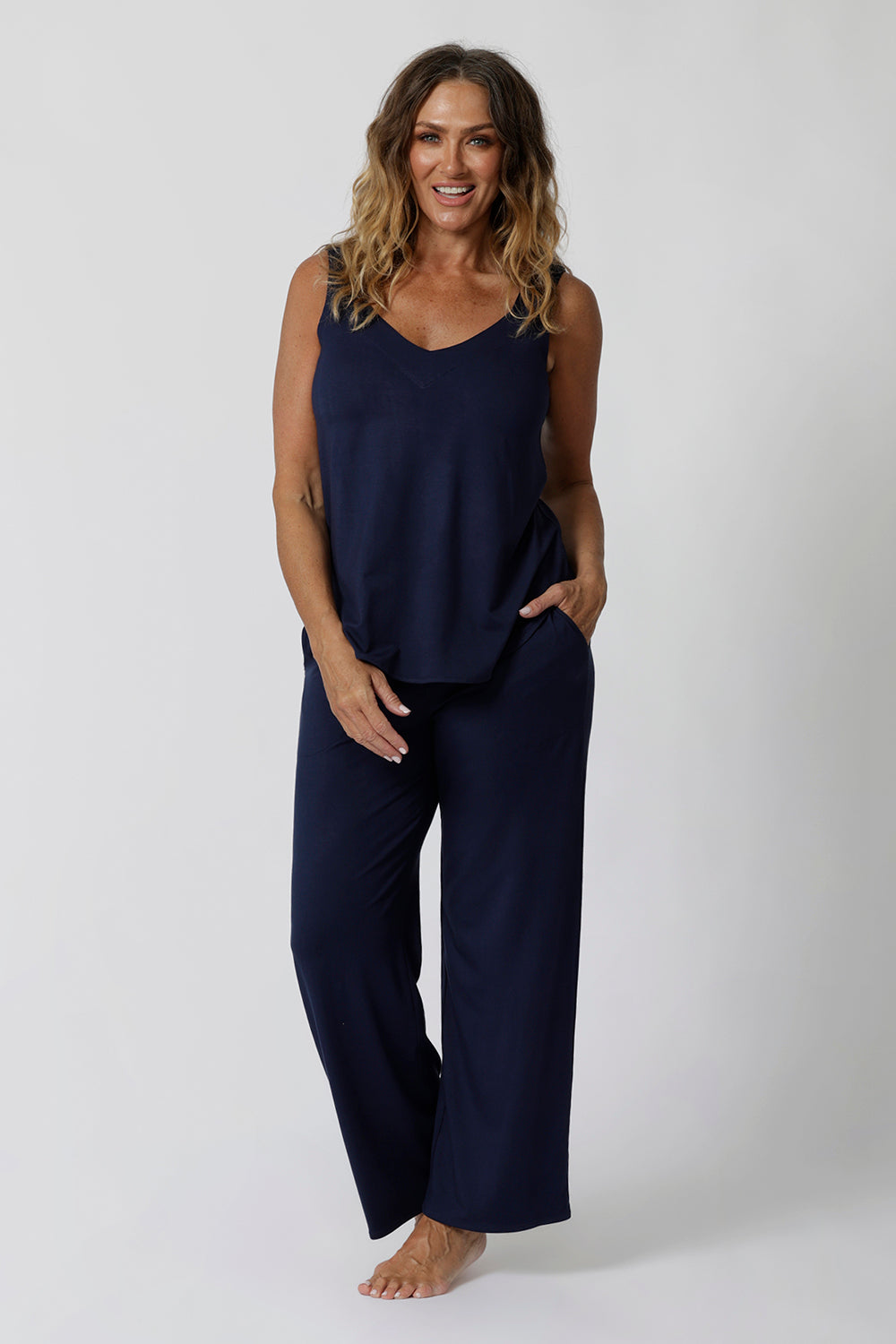 Showing good lounge pants for over 40s women, a size 12 woman wears straight, wide leg navy blue, plus size lounge pants in bamboo jersey with a blue bamboo jersey cami top. Breathable and thermo-regulating this is a good pyjama set  for night sweats and hot flushes. Stay cool for summer nights with breathable sleepwear by L&F Australia in sizes 8-24.