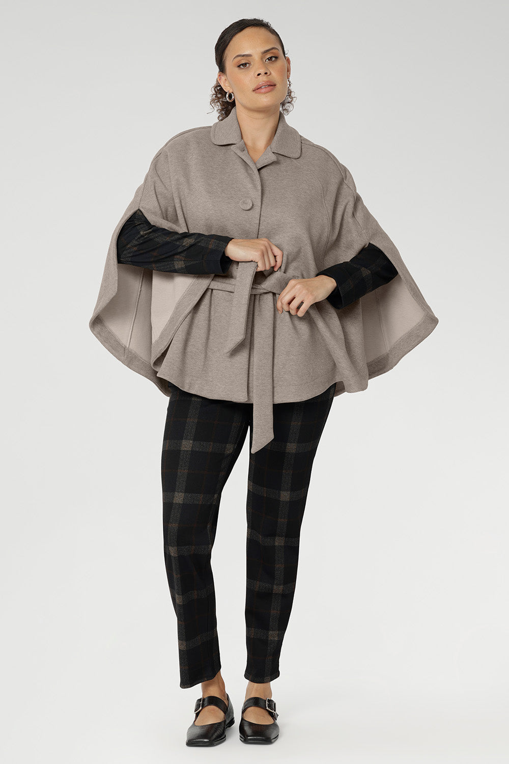Arm slits crafted into the sides allow for natural movement and create a graceful flare as you walk, adding fluidity and ease to every step. Unlike traditional belted coats, the back of this cape remains free from the tie, allowing the fabric to drape beautifully for full range of motion and an elegant finish.