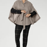 Arm slits crafted into the sides allow for natural movement and create a graceful flare as you walk, adding fluidity and ease to every step. Unlike traditional belted coats, the back of this cape remains free from the tie, allowing the fabric to drape beautifully for full range of motion and an elegant finish.