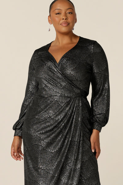 A fuller figure, size 18 woman wears a great cocktail dress for petite to plus size women. This long sleeve, wrap dress has a sweetheart neckline and below-the-knee skirt. The metallic foil print  shimmers for event and occasionwear. Made in Australia in sizes 8 to 24.