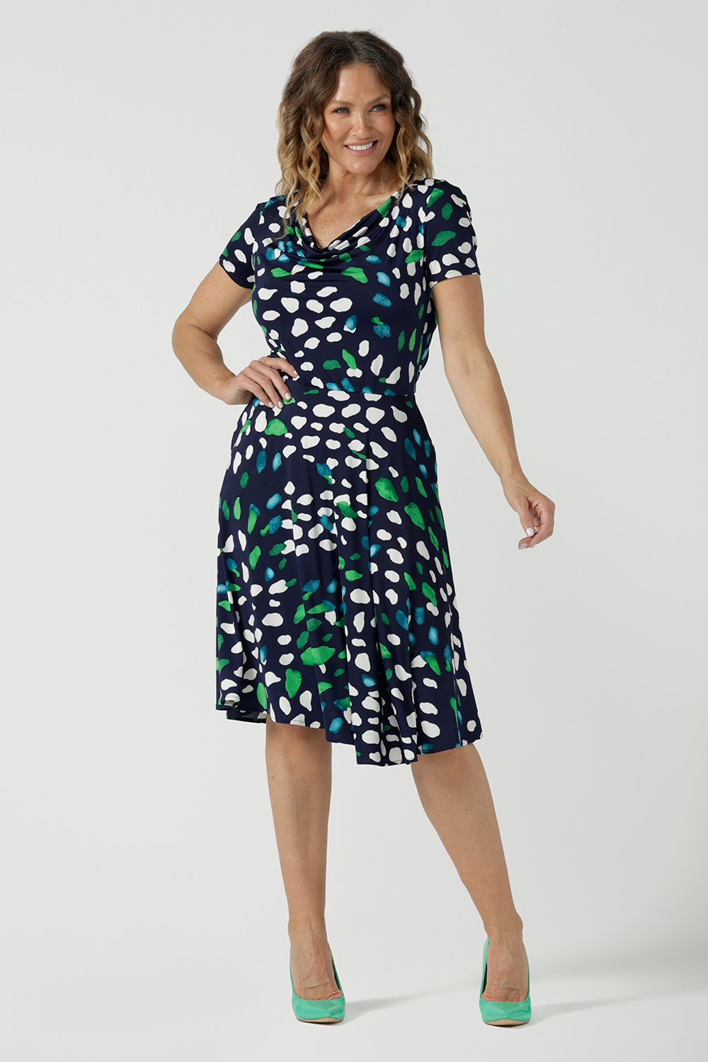 A great workwear dress for over 40 women, a size 12 woman wears the Casey dress with short sleeves, cowl neckline and knee length skirt. Made in sizes 8 to 24 by Australian and New Zealand women's fashion brand, Leina & Fleur this is also a good summer dress for plus size women, and with it's knee-length skirt, for petite women too. 