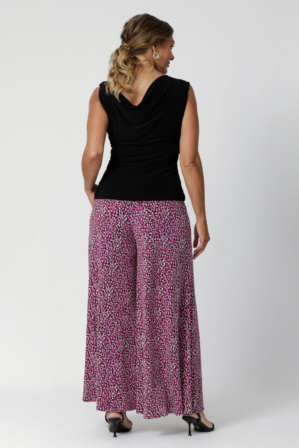 Palazzo pants feature a mid-rise cut and pull-on double-layer waistband to ensure a comfortable, secure fit while maintaining a sleek look. The side pockets are designed with visible stitch lines, adding a subtle, modern detail to the design. Over 40's model wears her palazzo pants in a size 12.