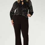 The Celine Top in Animal Burnout is a sophisticated statement piece, expertly crafted from luxurious velour fabric with a distinctive burnout effect. Designed to transition seamlessly from office wear to special events, this versatile blouse can be styled tucked in for a polished look or worn loose for effortless elegance.