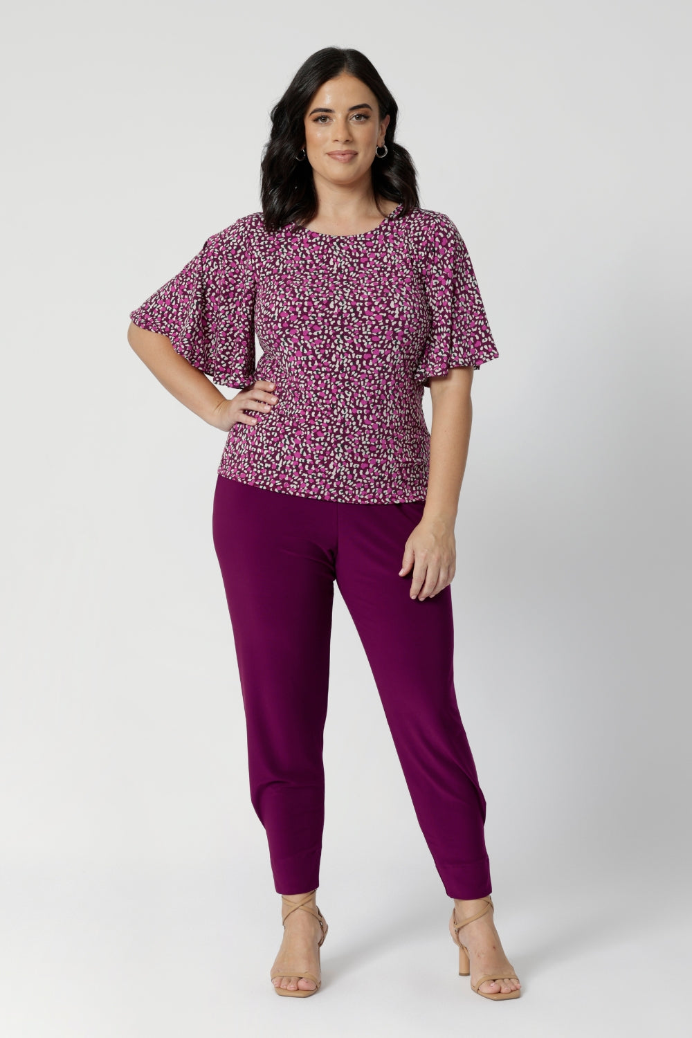 The rich tones of magenta, pink, graphite, and vanilla come together in a stunning print that catches the eye while remaining versatile enough to pair with a variety of pieces. Petite height model wears easy care top with magenta coloured pants and nude heel for an elevated look. Sizes 8-24 available in the Chloe Tops