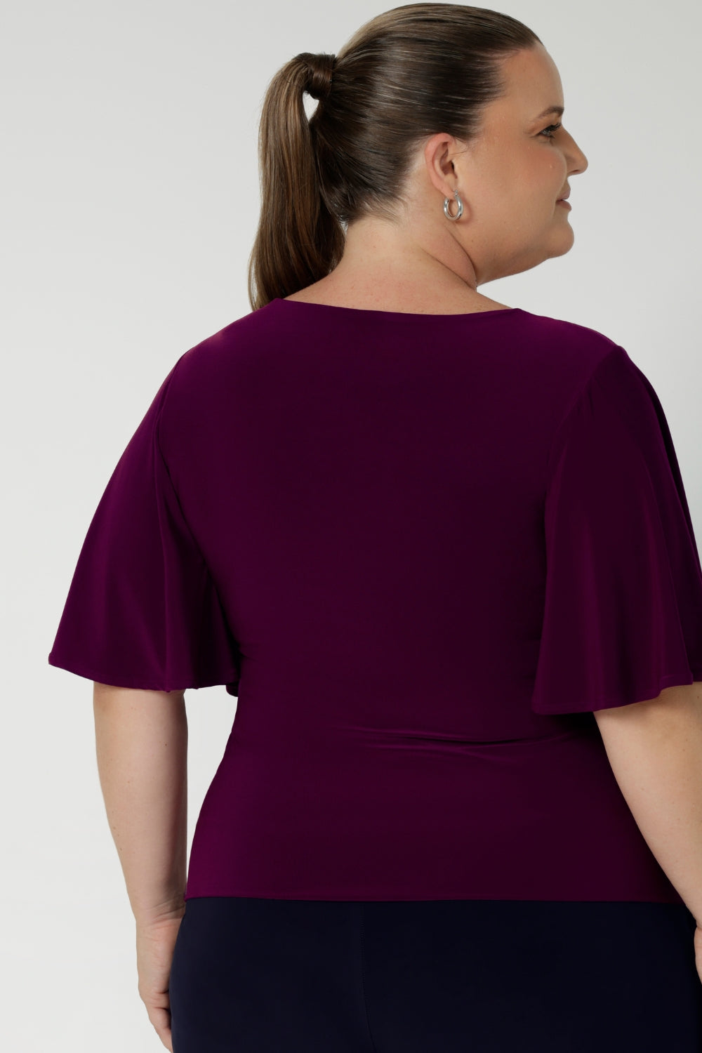 Woman's workwear top in Magenta features straight hemline - easy to tuck into skirts or trousers, making it a versatile piece for the corporate woman on the go. Available in size 8-24 by Australian Designer Leina & Fleur.