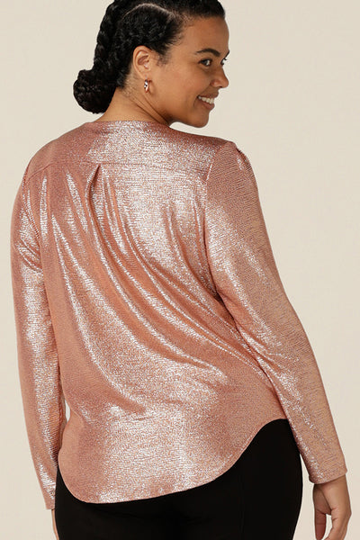 Back view of a  size 12 woman wearing a long sleeve occasionwear top with cowl neck in shimmering pink jersey fabric.  A great top for cocktail parties and special events, this Australian-made occasion wear top sparkles in sizes 8 to 24 .