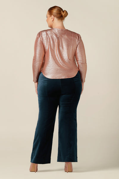 back view of a long sleeve occasionwear top with cowl neck in shimmering pink jersey fabric worn with flared leg velveteen cocktail wear pants. Both eveningwear garments are made in Australia in sizes 8 to 24 by Australian and New Zealand women's clothing brand, L&F.