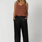 Over 40's model wears black back-to-work pant featuring a perfect blend of comfort and style for the office or any professional setting. Designed in a pull-on, mid-rise style, they offer an easy, seamless fit. The waistband features a bamboo jersey panel at the back, providing extra comfort around the waist and tummy area, ensuring a soft, flexible feel throughout the day.