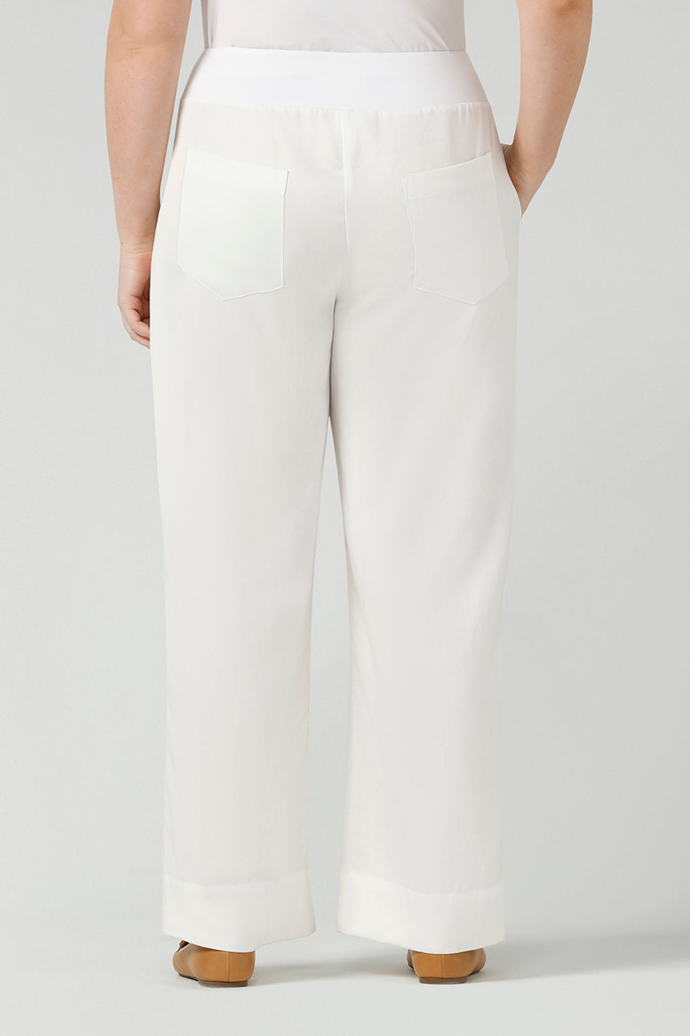 Back view of a curvy size, size 12 woman wearing wide leg pants with pockets. These pull-on, easy care pants are comfortable for your everyday workwear capsule wardrobe. Shop these Australian-made wide leg trousers online in sizes 8 to 24, petite to plus sizes.