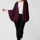 A size 10 woman wears a Bamboo Cove poncho wrap. Soft weighted bamboo that is a versatile work to travel and weekend piece. Made in Australia for women size 8 - 24. 