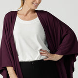 Front view of a size 10 woman wears a Bamboo Cove poncho wrap. Soft weighted bamboo that is a versatile work to travel and weekend piece. Made in Australia for women size 8 - 24. Mulberry colour.