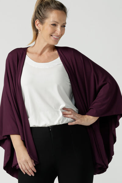 Front view of a size 10 woman wears a Bamboo Cove poncho wrap. Soft weighted bamboo that is a versatile work to travel and weekend piece. Made in Australia for women size 8 - 24. Mulberry colour.