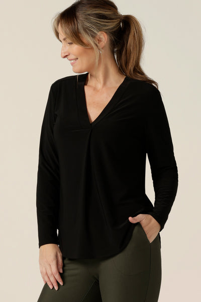 A size 10, 40 plus woman wears a long sleeve top with V-neck in black jersey. Australian made by Australian and New Zealand women's fashion brand, L&F .
