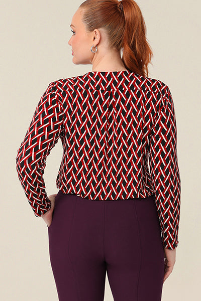 Back view of a long sleeve, women's work top. A red, white and black chevron print V-neck top, this tailored top is great for workwear. Worn by a curvy woman,  shop this office top at Australian fashion brand, L&F in petite to plus sizes.