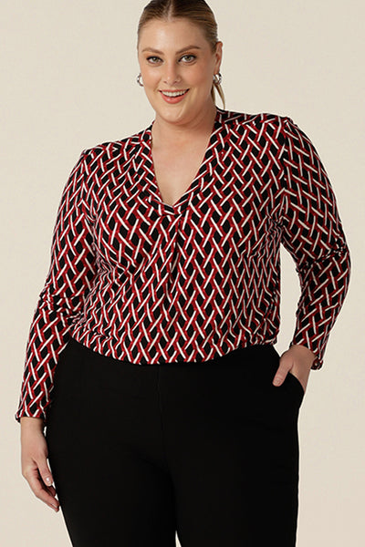 A long sleeve ladies work top, this red, white and black chevron print V-neck top has a shirttail hem. Worn by a plus size, size 18 woman,  shop this office top at Australian fashion brand, L&f in sizes 8 to 24.