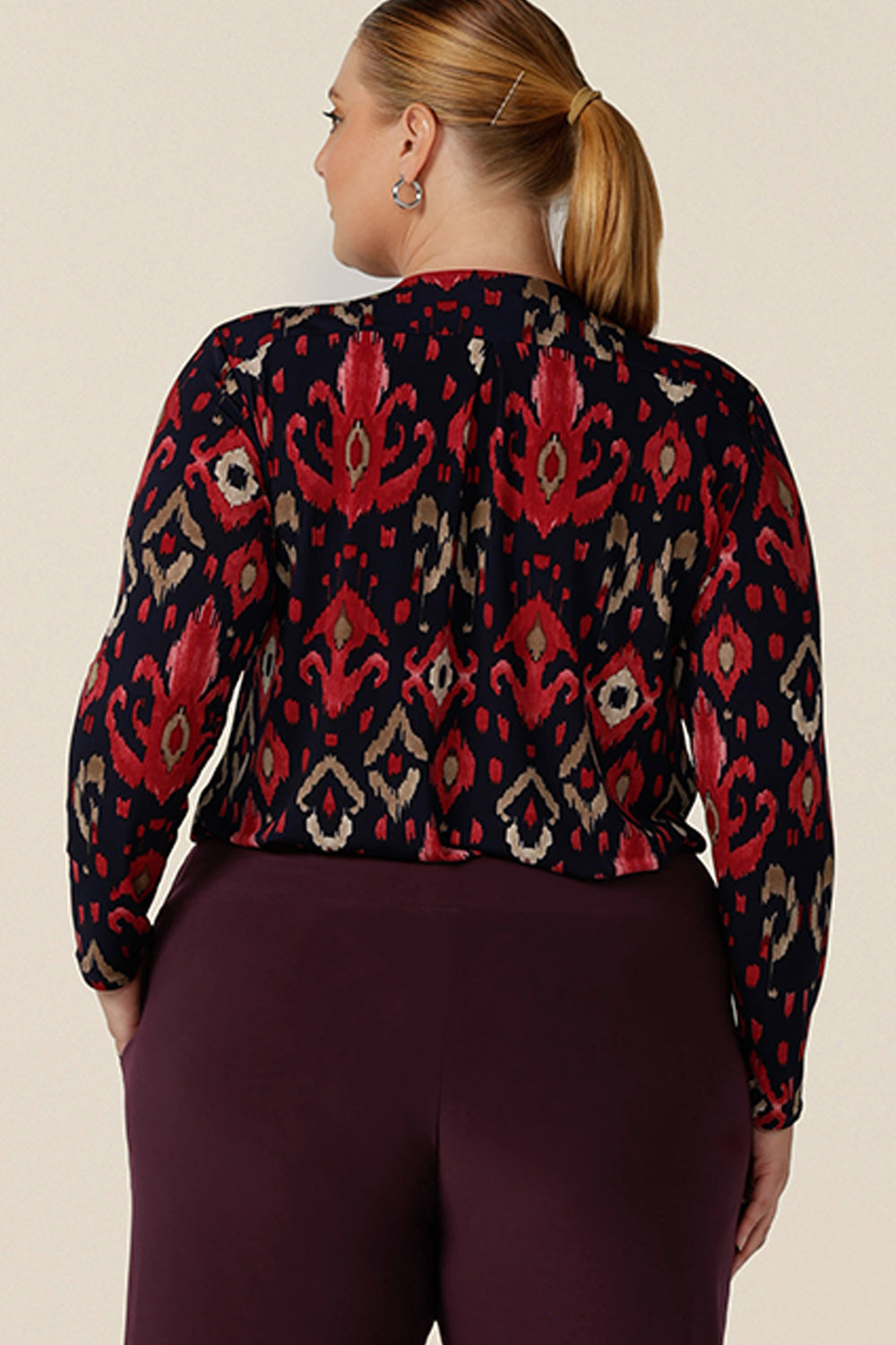 Back view of a great workwear top for women, the Dakota Top in Ikat is a V-neck, long sleeve top in soft stretch jersey. Shown here in a size 18 on a curvy woman, this top is made in Australia in sizes 8 to 24, petite to plus sizes.
