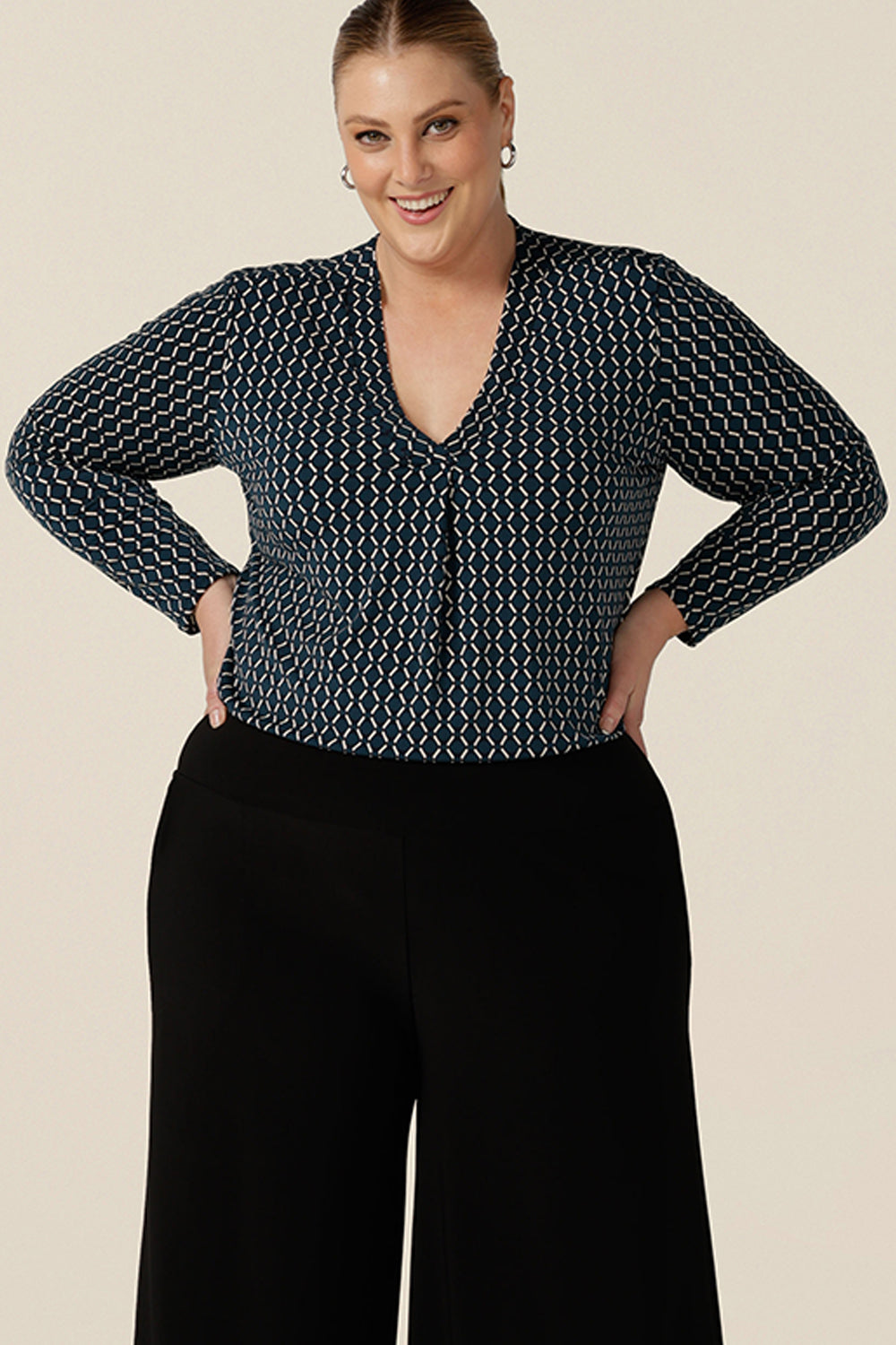 A good work wear top for plus size women, the long sleeved Dakota Top is a V neck top in blue and white Infinity print jersey. Worn with wide leg, navy work pants, both are made in Australia by Australian and New Zealand women's clothes brand, L&F, shop this smart top in sizes 8 to 24.