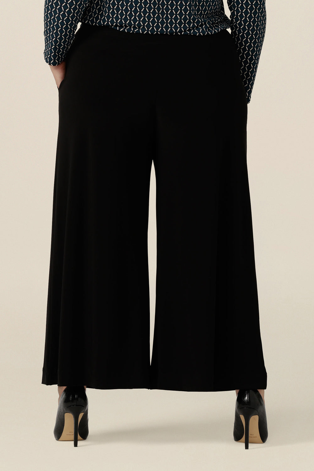 Back view of comfortable, black wide leg pants with pockets, shown in a size 18. These pull-on, easy care pants are comfortable for your everyday workwear capsule wardrobe. Shop these black pants online in sizes 8 to 24, petite to plus sizes.
