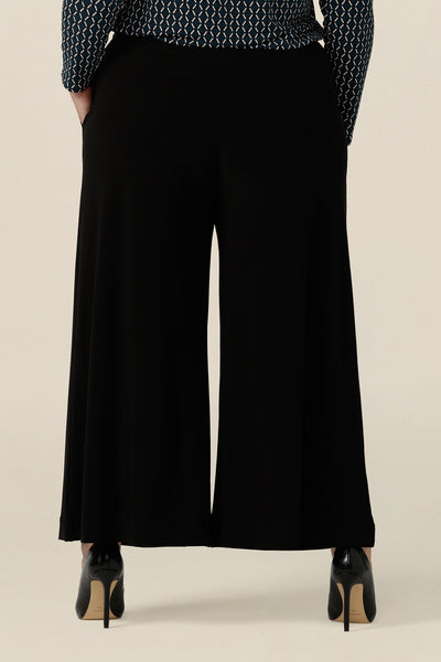 Back view of comfortable, black wide leg pants with pockets, shown in a size 18. These pull-on, easy care pants are comfortable for your everyday workwear capsule wardrobe. Shop these black pants online in sizes 8 to 24, petite to plus sizes.
