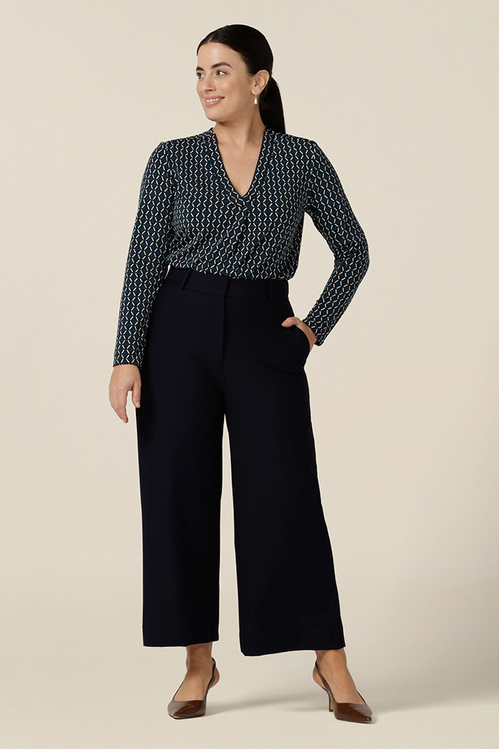 A good work wear top with long sleeves, the Dakota Top is a V neck top in blue and white Infinity print jersey. Worn with navy blue, tailored trousers, both are made in Australia by Australian and New Zealand women's clothes brand, L&F. Shop this smart top in sizes 8 to 24.
