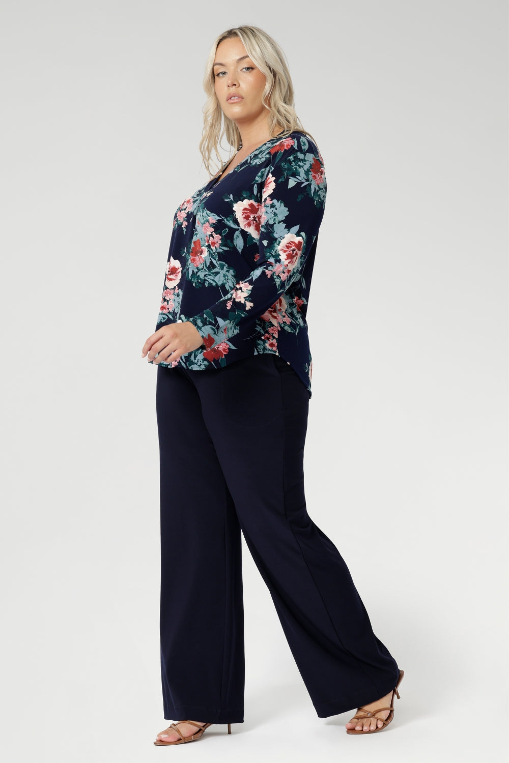 The floral pattern, highlighted in soft shades of pink, red, and blue, adds a timeless feminine touch while the stretch-infused fabric ensures all-day comfort and ease of movement.

A classic V-neckline is complemented by a tailored front tuck, creating a flattering silhouette that enhances your shape. Thoughtful design details such as a shoulder yoke with a center-back tuck and full-length sleeves provide structure and style. 