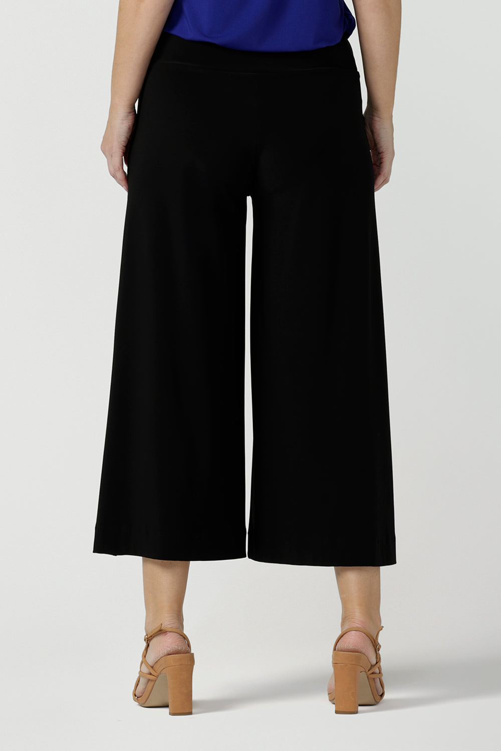 Back view of women's black wide-leg pants and a flutter sleeve top in Cobalt bamboo jersey. Cropped in length, the black pants have a smooth waistband, side pockets and are pull-on pants made in stretch jersey. Made in Australia, the pants are size inclusive in sizes 8 to sizes 24.