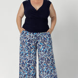 Plus size model wears printed wide leg culottes, paired with navy v neck work wear top and neutral heels for an elevated and seasonally appropriate look. The cropped length adds not only a modern appeal, but is perfect when considering many different heights. Danny Pants work for tall, short & regular height women.  Available in sizes 8-24.