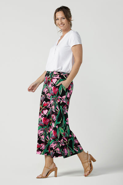 Side view of a size 10, 40 plus woman wears printed jersey, wide leg pants with a V-neck, short sleeve top in white bamboo jersey. Pull-on pants with a deep waistband, the cropped, culotte legs make great summer pants that work for petite heights as well as taller women. Shop pants online in sizes 8 to 24.