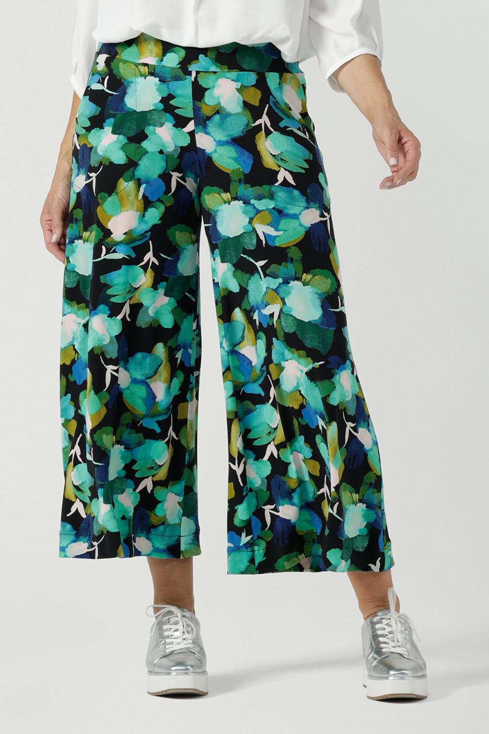 Size 12 woman wears the Dany culotte in Canopy, a wide leg culotte with the canopy print. A bold green colour splatter print. Styled back with nude heels and a white shirt. Made in Australia for women size 8 - 24. 