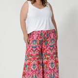 Plus sized woman wears cropped printed pants with summer cami in white to tie in with all the bold colours showcased in the print. Made from lightweight crepe jersey fabric, they offer cool and comfortable qualities making them ideal for travel. The jersey fabric’s stretch appeal is ideal for everyday comfort and style. Proudly stocked in sizes 8-24.