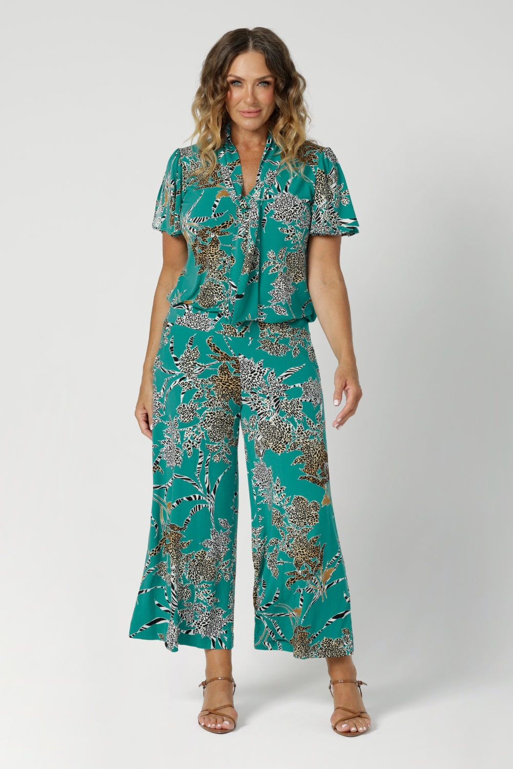 Part of Leina & Fleur's jade safari range, over 40's woman wears jade coloured ensemble with animal print details in a cropped culotte pant and matching printed top - creating faux jumpsuit look. Available in size 8-24.