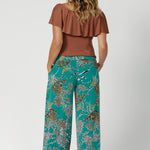 Back view of printed culotte pants worn by sizes 12 woman paired with clay coloured top. These Leina & Fleur Dany Pants are a highly sought-after style that combines comfort, versatility, and a flattering fit for all heights. Providing full-body stretch, flattering silhouette and all-day comfort for back to work and weekend events. Available in size 8-24.