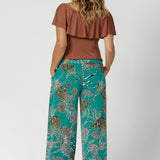 Back view of printed culotte pants worn by sizes 12 woman paired with clay coloured top. These Leina & Fleur Dany Pants are a highly sought-after style that combines comfort, versatility, and a flattering fit for all heights. Providing full-body stretch, flattering silhouette and all-day comfort for back to work and weekend events. Available in size 8-24.