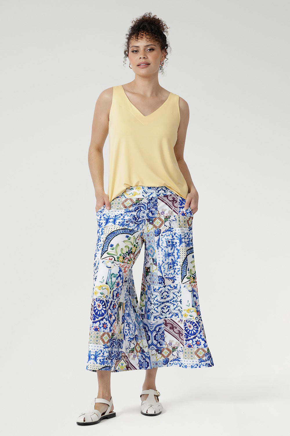 Crafted from our soft-touch stretch jersey, the Dany Culotte in Mosaic Tile captures the essence of Mediterranean elegance. Featuring an intricate Sicilian-style mosaic print in vibrant shades of cobalt, yellow, brown, and green on a crisp white base, these wide-leg culottes offer effortless movement and a beautifully fluid drape.