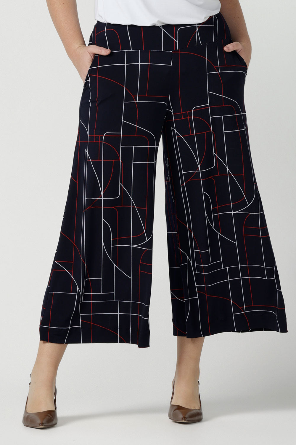 Close up of a size 12 woman wears the Dany Culotte in Navy Abstract. Corporate comfortable pant for women, geometric print with navy, red and white. Made in Australia for women size 8 - 24.